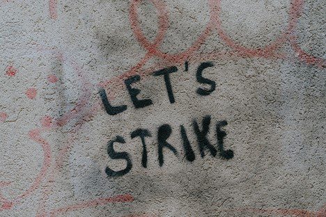 Graffiti reading "Let's Strike" on a concrete wall