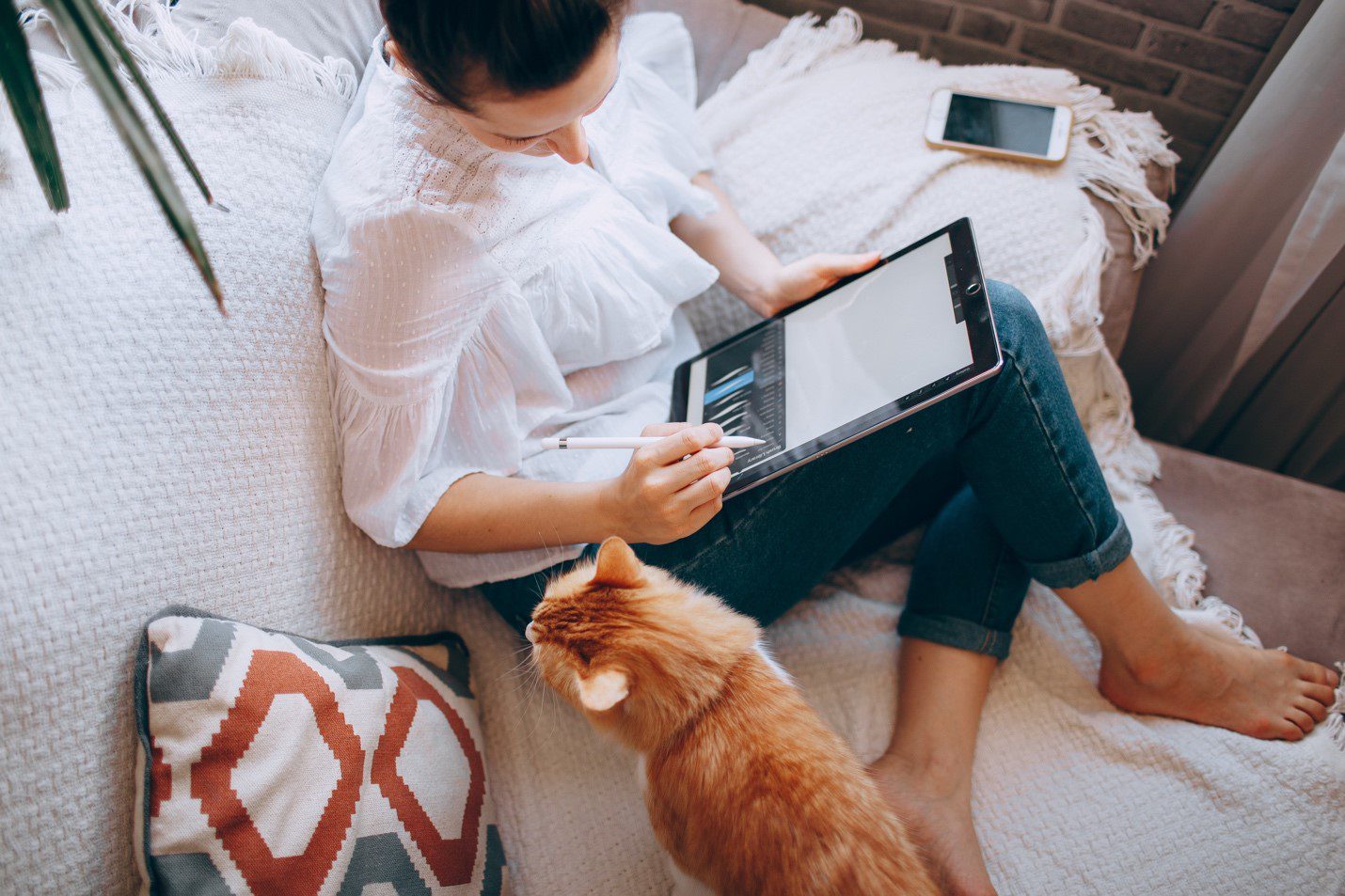 Woman on couch next to cat